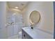 Bathroom featuring a walk-in tub, granite vanity and round mirror at 4188 Muirfield Loop, Lake Wales, FL 33859