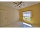 Bright bedroom with tile flooring, ceiling fan, and outdoor view at 4188 Muirfield Loop, Lake Wales, FL 33859