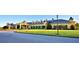 A view of the golf cart parking area, and beautifully landscaped clubhouse with elegant architecture at 4188 Muirfield Loop, Lake Wales, FL 33859