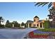 Scenic entrance to Lake Akea featuring colorful flowerbeds, a gatehouse, and lush landscaping at 4188 Muirfield Loop, Lake Wales, FL 33859