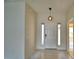 Bright foyer with marble flooring, a modern pendant light, and sidelight windows flanking the entry door at 4188 Muirfield Loop, Lake Wales, FL 33859