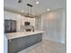 Modern kitchen with white cabinets, stainless steel appliances, and a spacious gray island at 4188 Muirfield Loop, Lake Wales, FL 33859