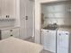 Laundry room area with washer and dryer hookups, shelving, and white cabinets at 4188 Muirfield Loop, Lake Wales, FL 33859