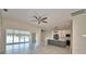Bright living room with serene water view, ceiling fan, and open floor plan connecting to kitchen and dining at 4188 Muirfield Loop, Lake Wales, FL 33859