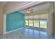 Bright living room with large windows overlooking the water, tile floors, and ceiling fan at 4188 Muirfield Loop, Lake Wales, FL 33859