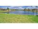 Scenic view of a tranquil pond surrounded by lush green grass and well-maintained landscaping at 4188 Muirfield Loop, Lake Wales, FL 33859