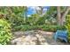 A backyard fire pit with stone patio and tropical landscaping and blue chairs at 4219 Forest Hills Dr, Lakeland, FL 33813