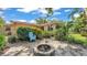 Backyard fire pit with a stone patio, tropical landscaping, and a blue chair at 4219 Forest Hills Dr, Lakeland, FL 33813