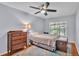 This bedroom has wood floors, a ceiling fan, and a trunk at the end of the bed at 4219 Forest Hills Dr, Lakeland, FL 33813