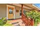 Inviting front porch with a yellow door, brick steps, and lush greenery, creating a warm welcome at 4219 Forest Hills Dr, Lakeland, FL 33813