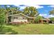 Charming single-story home featuring a lush front yard with tropical landscaping and mature trees at 4219 Forest Hills Dr, Lakeland, FL 33813