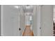 Bright hallway with hardwood floors, featuring doors to other rooms with decorative light fixtures at 4219 Forest Hills Dr, Lakeland, FL 33813