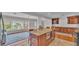 Open kitchen featuring a granite island with seating, tiled floor, and wooden cabinetry at 4219 Forest Hills Dr, Lakeland, FL 33813