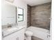 Bathroom with wood-look tile feature wall and granite countertop at 5409 Waterside Dr, Auburndale, FL 33823