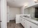 Bright bathroom showcasing double sinks, granite counters, and wood look tile floors at 5409 Waterside Dr, Auburndale, FL 33823