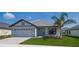 Charming one-story home with a landscaped yard and a beautiful front door and a paved driveway at 5409 Waterside Dr, Auburndale, FL 33823