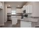 Modern kitchen features white cabinets, granite countertops, stainless steel appliances, and an island at 5409 Waterside Dr, Auburndale, FL 33823