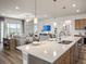 Open-concept living area with modern furnishings, adjacent to a kitchen with island seating at 557 Silver Course Radl, Ocala, FL 34472