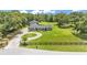 Scenic aerial view of the property featuring a large front yard, circular driveway and surrounding trees at 59 Jimmy Lee Rd, Winter Haven, FL 33880