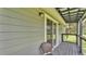 Cozy covered balcony with a comfortable chair for outdoor relaxation and view enjoyment at 59 Jimmy Lee Rd, Winter Haven, FL 33880
