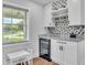 Bar area with wine refrigerator, overhead glassware storage and backyard view at 59 Jimmy Lee Rd, Winter Haven, FL 33880