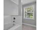 Bright bathroom features a tiled tub with chrome fixtures and a window letting in natural light at 59 Jimmy Lee Rd, Winter Haven, FL 33880
