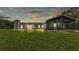 Rear exterior of a gray home, showcasing a chimney, deck, and covered porch with modern lighting at 59 Jimmy Lee Rd, Winter Haven, FL 33880