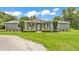 Inviting single-story home with a well-manicured lawn, featuring a charming front porch and lush landscaping at 59 Jimmy Lee Rd, Winter Haven, FL 33880