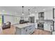Open concept kitchen with gray island, seating, stainless appliances and view to living spaces at 59 Jimmy Lee Rd, Winter Haven, FL 33880