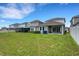 Well-kept backyard with healthy green grass, white privacy fence, and sliding glass doors at 6261 Great Bear Dr, Lakeland, FL 33805