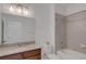 Well-lit bathroom featuring granite countertops, wood cabinets, and shower-tub combo at 6261 Great Bear Dr, Lakeland, FL 33805