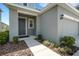 Inviting front porch with a gray front door, small garden and exterior light fixture at 6261 Great Bear Dr, Lakeland, FL 33805
