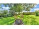 Spacious backyard features lush lawn, seating, mature landscaping and a fire pit, perfect for outdoor enjoyment at 633 Hart Lake Dr, Winter Haven, FL 33884