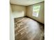 Neutral-toned bedroom with wood-look flooring and a window providing natural light at 711 Whispering Pines Dr, Auburndale, FL 33823