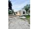 New single story home with tan siding, black shutters, and a visible serial number on the front at 711 Whispering Pines Dr, Auburndale, FL 33823