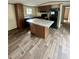 Modern kitchen with an island, dark cabinets, stone countertops and modern appliances at 711 Whispering Pines Dr, Auburndale, FL 33823
