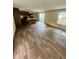 Open-concept living room featuring wood-look flooring, kitchen view, and a sliding glass door at 711 Whispering Pines Dr, Auburndale, FL 33823
