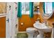 Cozy bathroom with a pedestal sink, wood paneling, natural light from the window, and mermaid-themed shower curtain at 819 Glendale St, Lakeland, FL 33803
