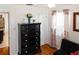 This bedroom features a dark dresser with silver hardware, colorful curtains, and hardwood floors at 819 Glendale St, Lakeland, FL 33803
