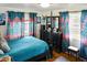 Bright bedroom with hardwood floors, colorful curtains, and a comfortable queen-sized bed at 819 Glendale St, Lakeland, FL 33803