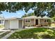 Charming single-story home with neutral siding, green lawn and complemented by mature trees overhead at 819 Glendale St, Lakeland, FL 33803