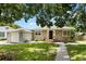 Charming single-story home with neutral siding, green lawn and complemented by mature trees overhead at 819 Glendale St, Lakeland, FL 33803