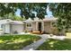 Charming home featuring a gray exterior, a well-manicured lawn, and a connecting single-car garage at 819 Glendale St, Lakeland, FL 33803