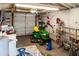 A spacious garage featuring a lawn mower, storage shelves, and potential space for laundry equipment at 819 Glendale St, Lakeland, FL 33803