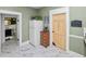 Bright kitchen showcasing a refrigerator, adjacent bathroom and natural wood accent door and drawers at 918 South Blvd, Lakeland, FL 33803