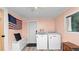 This laundry room includes a washer, dryer, American flag, storage bench, and laminate floors at 918 South Blvd, Lakeland, FL 33803