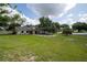 Spacious backyard with a screened-in pool, lush green lawn, and mature trees, perfect for outdoor enjoyment at 929 Hammock Shade Dr, Lakeland, FL 33809