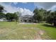 View of the backyard, with a privacy fence, mature trees, grassy lawn and the pool area at 929 Hammock Shade Dr, Lakeland, FL 33809