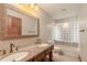Bathroom with dual sinks and bathtub with decorative tile surround at 929 Hammock Shade Dr, Lakeland, FL 33809