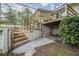 An exterior shot of a raised deck, stairs, and a concrete patio that leads out to the pool area at 929 Hammock Shade Dr, Lakeland, FL 33809